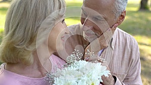 Senior man giving flowers to beloved woman, pleasant date surprise, anniversary