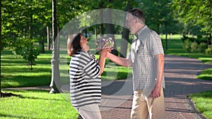 Senior man giving flowers to woman at the park.
