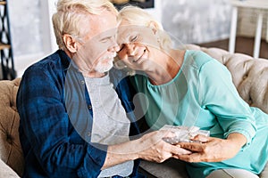 Senior man giving a gift to senior woman at home