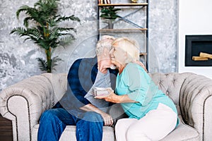 Senior man giving a gift to senior woman at home