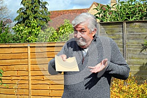 Senior man giving a plain brown envelope.