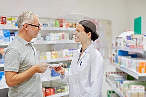 Senior man giving prescription to pharmacist