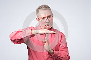 Senior man giving showing time out hands gesture