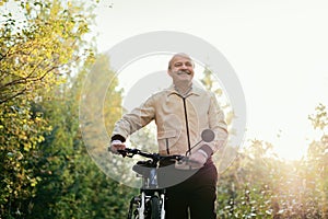 Senior man go for a walk with bike in countryside