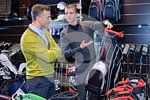 Senior man in golf store talking to shop assistant