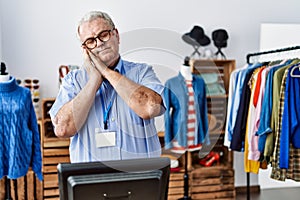 Senior man with grey hair working as manager at retail boutique sleeping tired dreaming and posing with hands together while