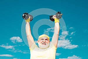 Senior man in gym working out with weights. Summer and active holidays. Portrait of senior man holding dumbbell. Senior