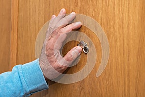 Senior man hand open the peephole cover door