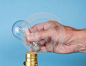 Senior man hand unscrewing the halogen bulb