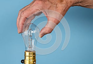 Senior man hand unscrewing the halogen bulb