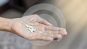 The senior man hands putting pills in his hand. The Old man taking care himself for health. Health and Medical concept