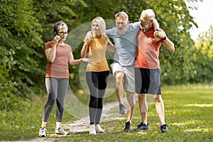 Senior man having leg injury during group training with friends outdoors