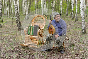 Senior man is having rest in birch forest