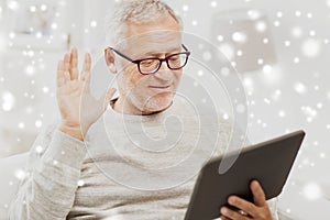 Senior man having video call on tablet pc at home