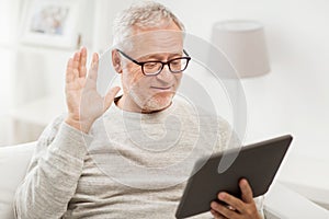 Senior man having video call on tablet pc at home