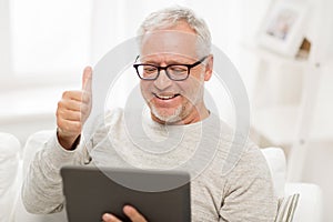 Senior man having video call on tablet pc at home