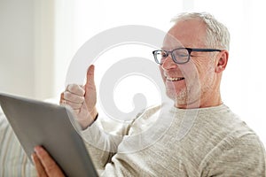 Senior man having video call on tablet pc at home