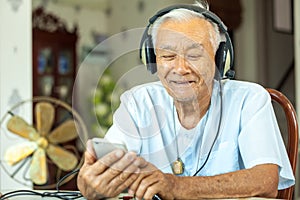 Senior man Headphones Listening Music at home