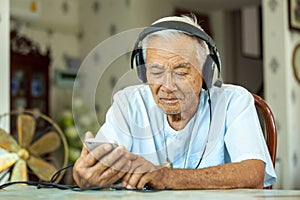 Senior man Headphones Listening Music at home