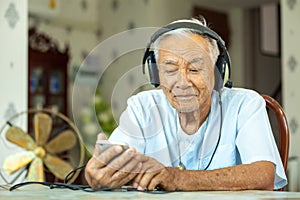 Senior man Headphones Listening Music at home