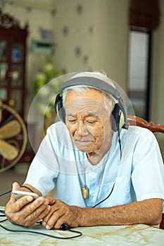 Senior man Headphones Listening Music at home