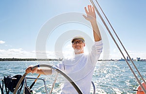 Senior man at helm on boat or yacht sailing in sea