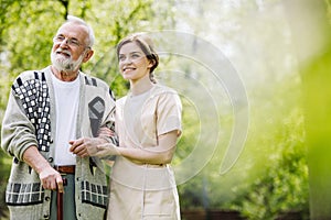 man with helpful volunteer in the garden of professional care home