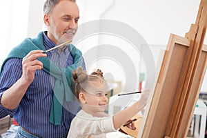 Senior man and his grandchild drawing an image