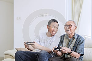 Senior man and his son playing video games
