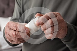 Senior man holding bottle with pills in his hands