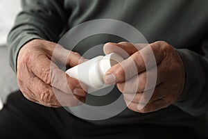 Senior man holding bottle with pills in his hands