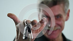 Senior man holding car key isolated on white