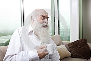 Senior man holding coffee cup at home