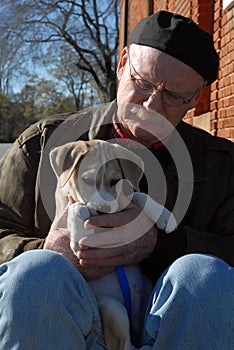 Senior man holding cute puppy