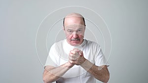 Senior man holding fist together.