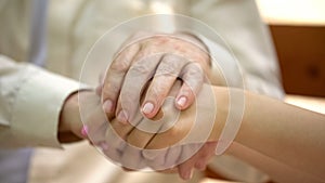 Senior man holding hand of young woman, support and care of relative concept