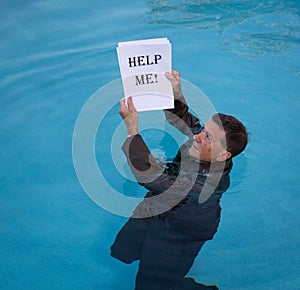 Senior man holding help me paperwork in water