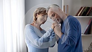 Senior man holding his wife hands, touching silky skin, enjoying tenderness