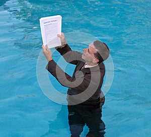 Senior man holding mortgage loan document in water