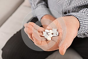 Senior man holding pills in hand