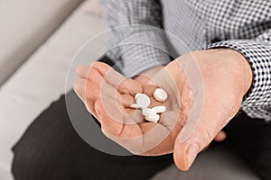 Senior man holding pills in hand