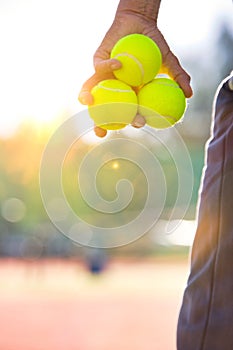 Senior man holding tennis balls on court