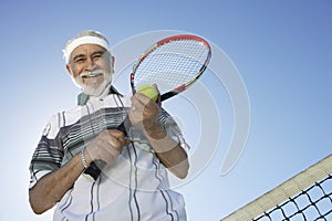 Senior Man Holding Tennis Racquet And Ball photo