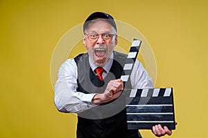Senior man holds film flap close up. Film directing. Film production. Human emotions. Man with movie flap while filming