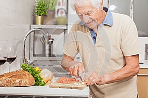 SENIOR MAN AT HOME IN THE KITCHEN