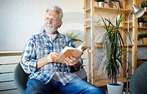 Senior man at home reading book and enjoying retirement, penison