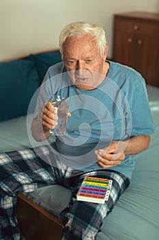 Senior Man At Home Taking Medication