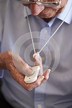 Senior Man At Home Using Distress Alarm Call Button