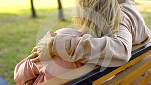 Senior man hugging woman sitting in park, romantic relationships, togetherness