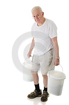 Senior Man Hunched Carrying Buckets photo